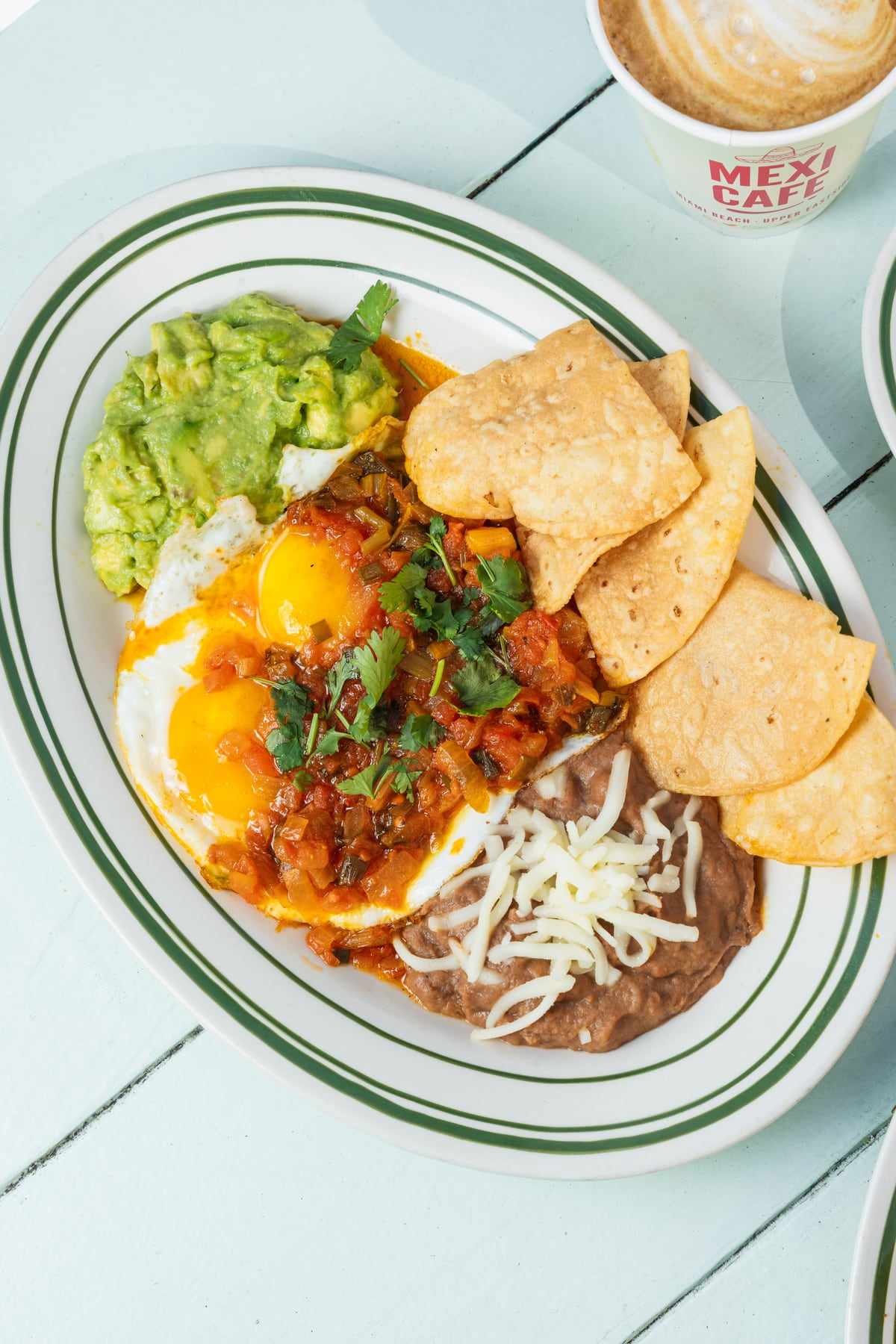 Huevos rancheros: two fried eggs in ranchera sauce with refried beans, guacamole and tortilla chips